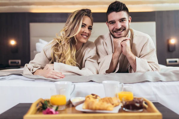 Giovane coppia felice fare colazione in camera d'albergo di lusso . — Foto Stock