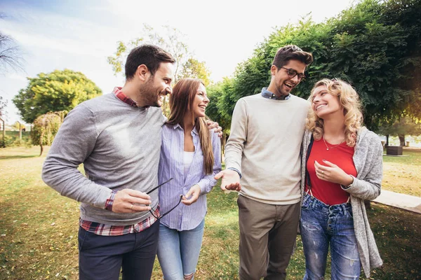 Groupe de jeunes marchant dans le parc. Amis s'amuser o — Photo