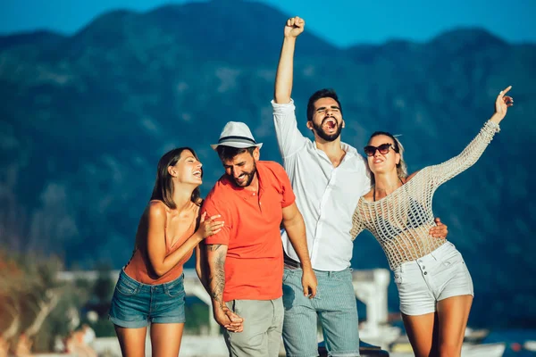 Amici passeggiando vicino al porto di una località balneare turistica con boa — Foto Stock