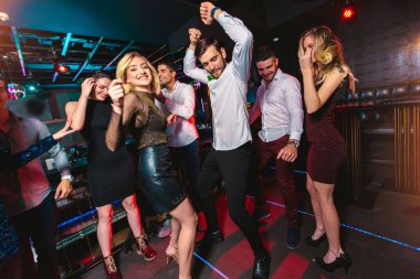 Genç mutlu insanlar kulüpte dans ediyor. Gece hayatı ve disko konc