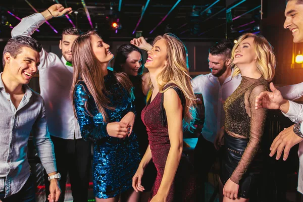 Jovens felizes estão dançando no clube. Vida noturna e discoteca conc — Fotografia de Stock