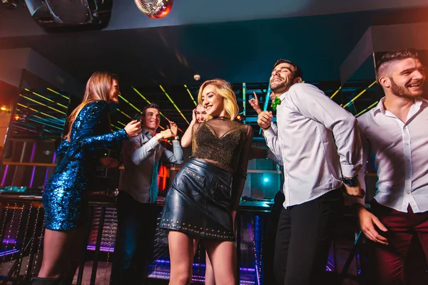 Jonge gelukkige mensen dansen in de club. Uitgaansleven en discotheek — Stockfoto