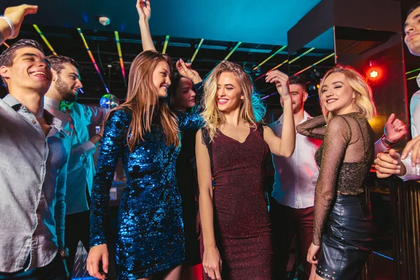 Jovens felizes estão dançando no clube. Vida noturna e discoteca conc — Fotografia de Stock