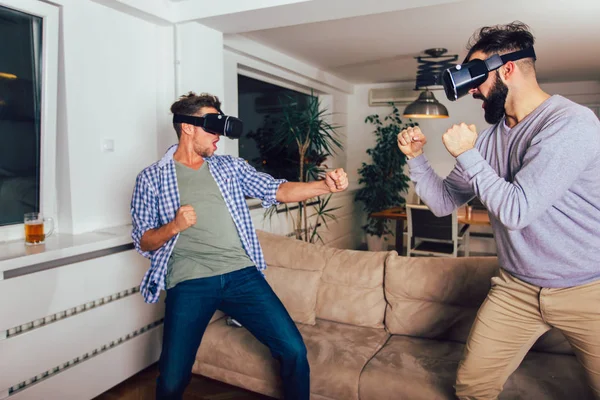 Happy friends playing video games with virtual reality glasses -