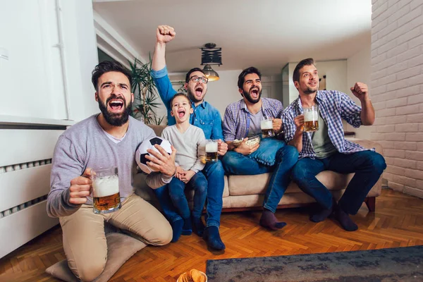 Männer, die zu Hause gemeinsam Sport im Fernsehen gucken und fröhlich schreien. gr — Stockfoto