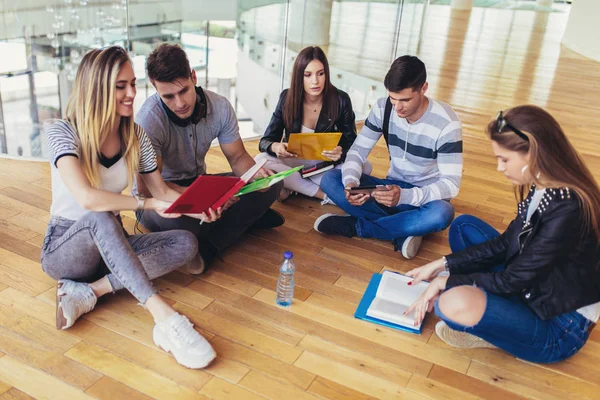 Fellow students sitting on floor in campus and preparing togethe — Stock Photo, Image