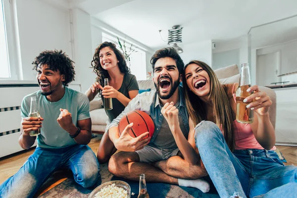 Šťastné přátele nebo basketbalové fanoušky, kteří sledují basketbal v televizi — Stock fotografie