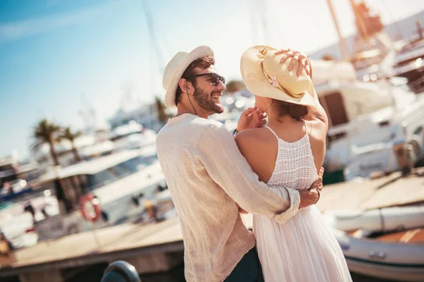 Gelukkige jonge paar wandeling door de haven van een toeristische zee reso — Stockfoto