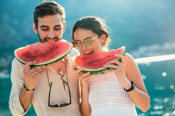 Vrolijk paar met plakjes watermeloen — Stockfoto