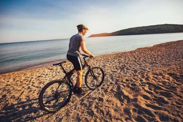 Homem passeio de bicicleta de montanha na praia. Desporto e vida activa — Fotografia de Stock