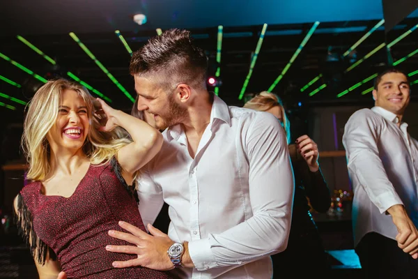 Jovens felizes estão dançando no clube. Vida noturna e discoteca conc — Fotografia de Stock