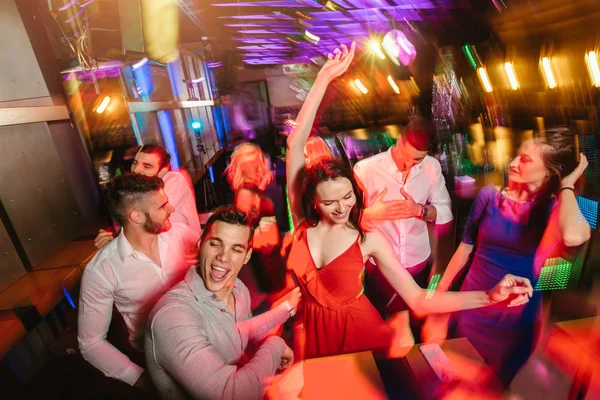 Young happy people are dancing in club. Nightlife and disco conc — Stock Photo, Image