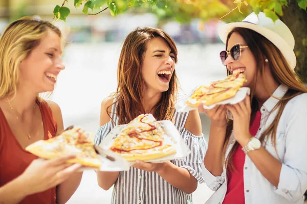 Drie mooie jonge vrouwen pizza eten na het winkelen, gelet — Stockfoto