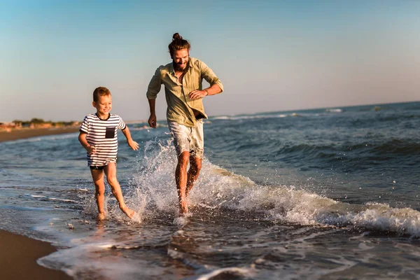 Счастливый отец и сын, мужчина и мальчик, бегающий и веселящийся — стоковое фото