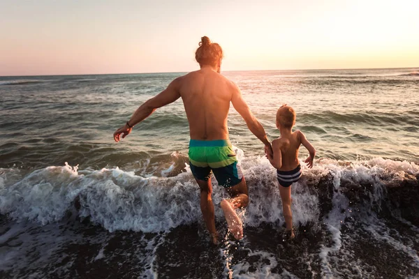 Отец и сын играют на пляже в дневное время — стоковое фото