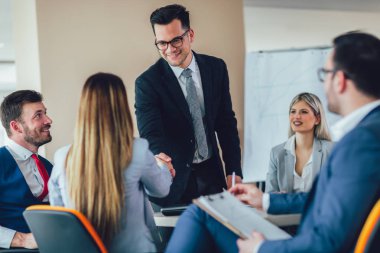 Ofiste bir müşteri ile el sallayarak iş 