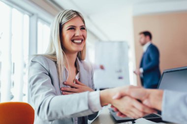 Ofiste bir müşteri ile el sallayarak iş 