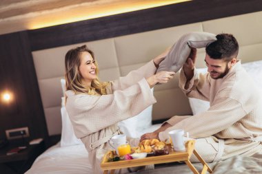 otel odasında yastık sahip mutlu bir çift kavga 