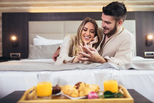 年轻幸福的夫妇在豪华酒店房间吃早餐. — 图库照片