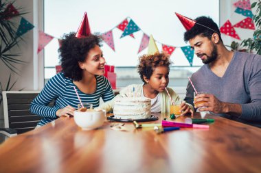 Mutlu bir aile evde doğum gününü kutluyor. 