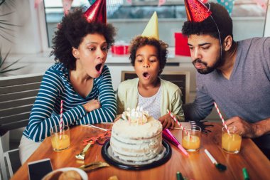 Mutlu bir aile evde doğum gününü kutluyor. 