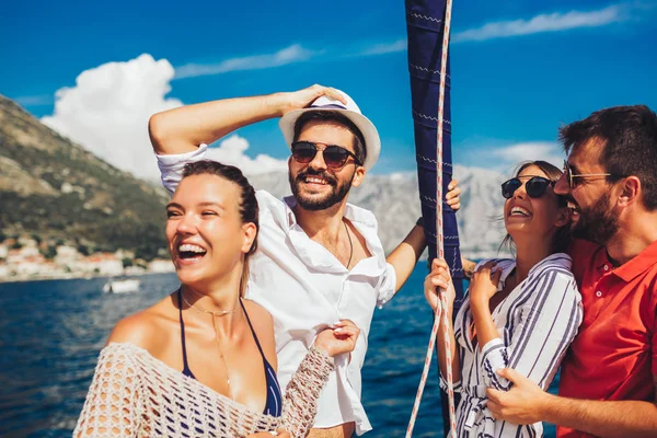 Amigos sonrientes navegando en yate - vacaciones, viajes, mar, amigo — Foto de Stock