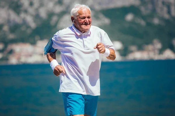 Senior lycklig gör morgonträning på stranden — Stockfoto