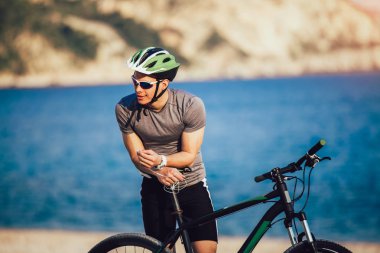 Kask ve güneş gözlüğü dinleme ile dağ bisikletçinin portresi 