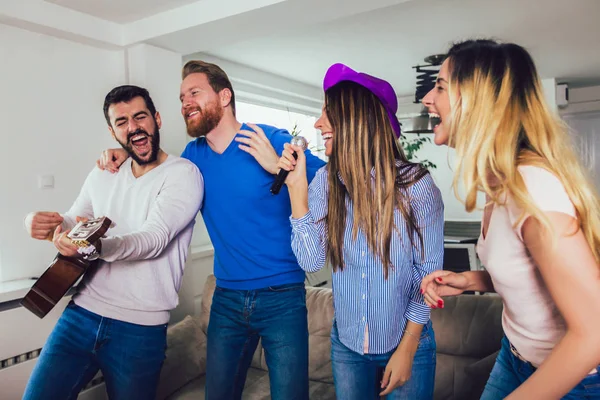 Grupo de amigos jugando karaoke en casa. Concepto acerca de friendsh — Foto de Stock