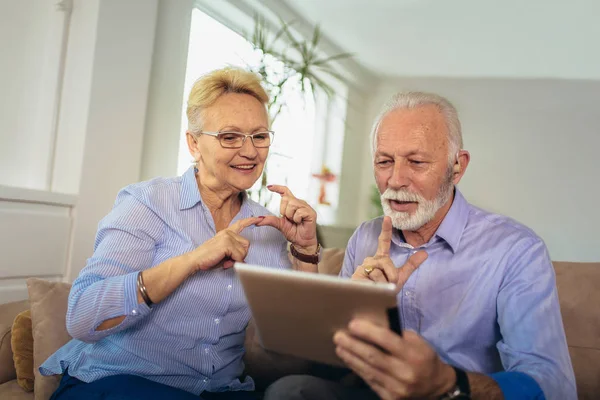 Sonriendo sorda pareja de personas mayores hablando usando lenguaje de señas en el di —  Fotos de Stock