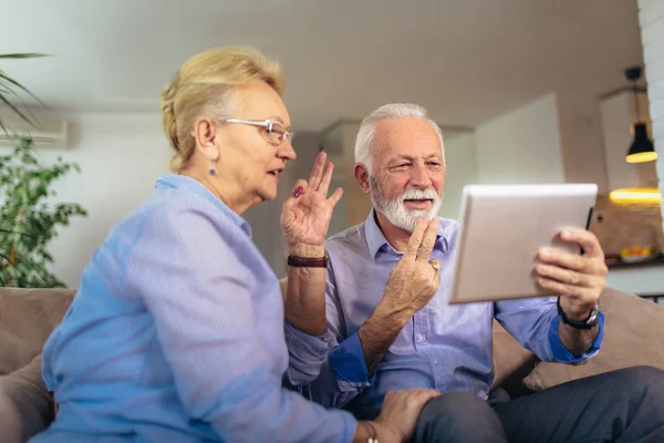 Sorrindo casal de idosos surdos falando usando linguagem gestual no di — Fotografia de Stock