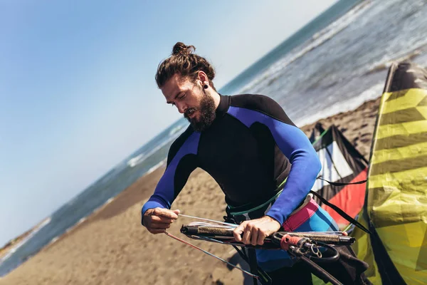 Wetsuits uçurtma donanımları için dalga köpüğü ile adam sufrers.
