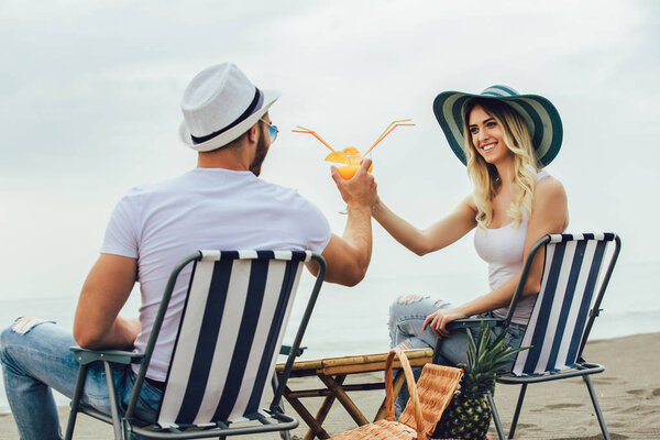 Couple on a deck chair relaxing on the beach. Happy couple enjoy