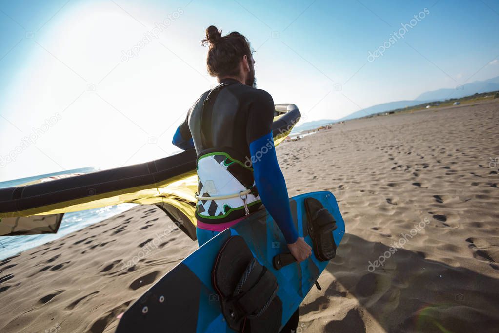 Handsome Caucasian man professional surfer standing  on the sand