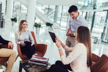 İş ekibi yeni proje üzerinde çalışıyor ve gülümsüyor. Erkek ve kadın 