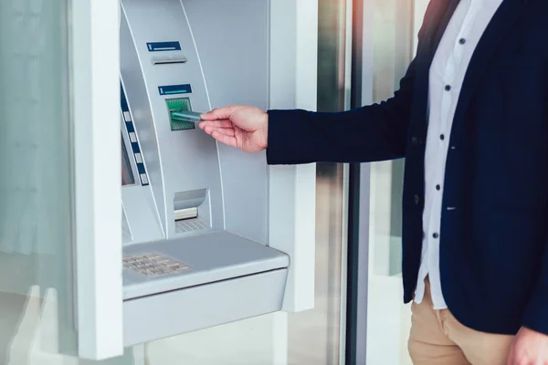 Zaken man die ATM gebruikt. persoon die creditcard gebruikt om in te trekken — Stockfoto