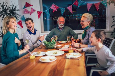 Çoklu nesil aile evde yemek masası etrafında keyfi