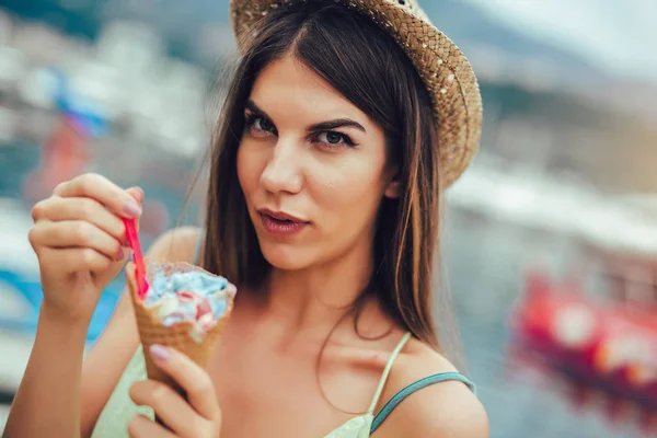 Woman eating ice cream outside on summer vacation in holiday bea