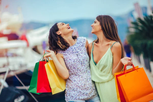 Female friends with shopping bags walking by the harbor of a tou — Stock Photo, Image