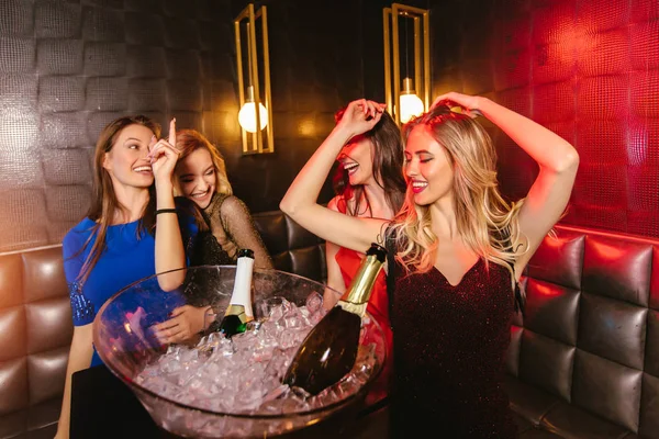 Mujeres felices tintineando copas de champán y celebrando por la noche — Foto de Stock