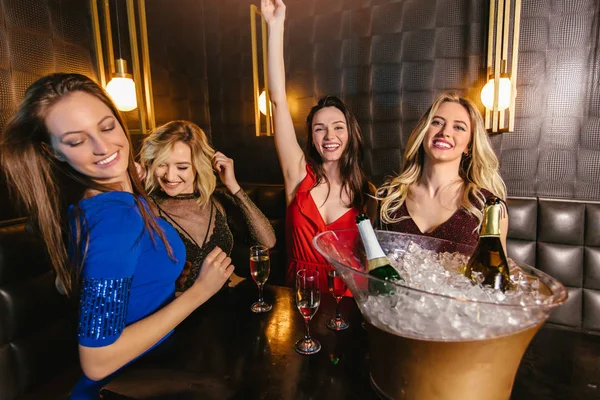 Mujeres felices tintineando copas de champán y celebrando por la noche — Foto de Stock