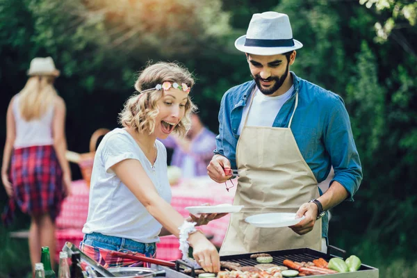 Szórakoztatóbb barátok a hús grillezés Party élvezve. — Stock Fotó