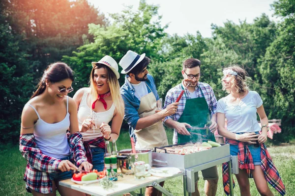 Jonge vrienden met plezier grillen vlees genieten van barbecuefeest. — Stockfoto
