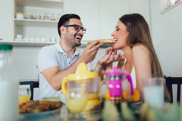 Pareja feliz disfrutando del desayuno juntos en casa. — Foto de Stock