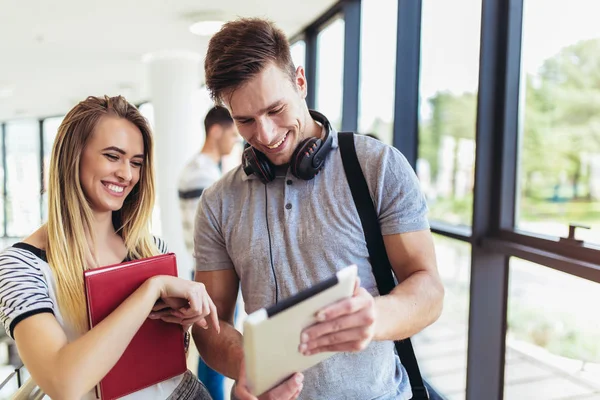 Twee studenten met behulp van zij digitale tablet aan een universiteit. — Stockfoto