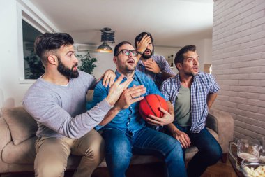 Mutlu arkadaşlar veya basketbol taraftarları televizyonda basketbol oyunu izlerken 
