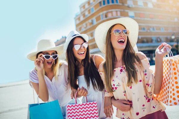Lyckliga unga flickor gå på gatan med shoppingväskor. (Söderby) — Stockfoto