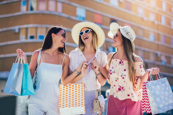 Lyckliga unga flickor gå på gatan med shoppingväskor. (Söderby) — Stockfoto