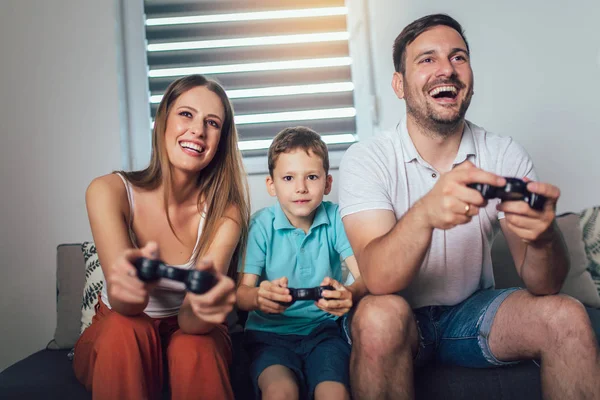Familia feliz jugando videojuegos en casa y divirtiéndose juntos —  Fotos de Stock