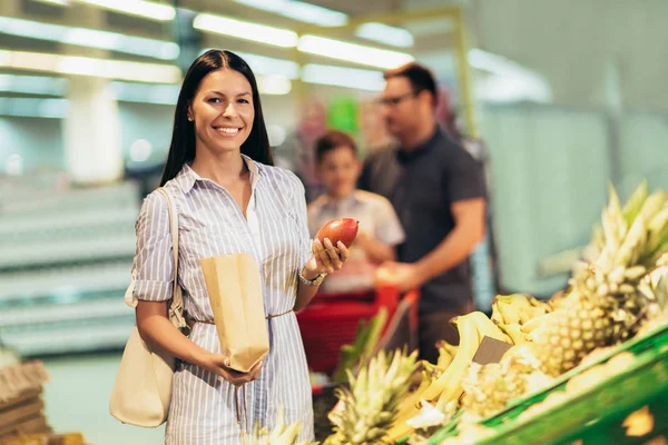 Mujer feliz está comprando frutas y verduras frescas en el super — Foto de Stock